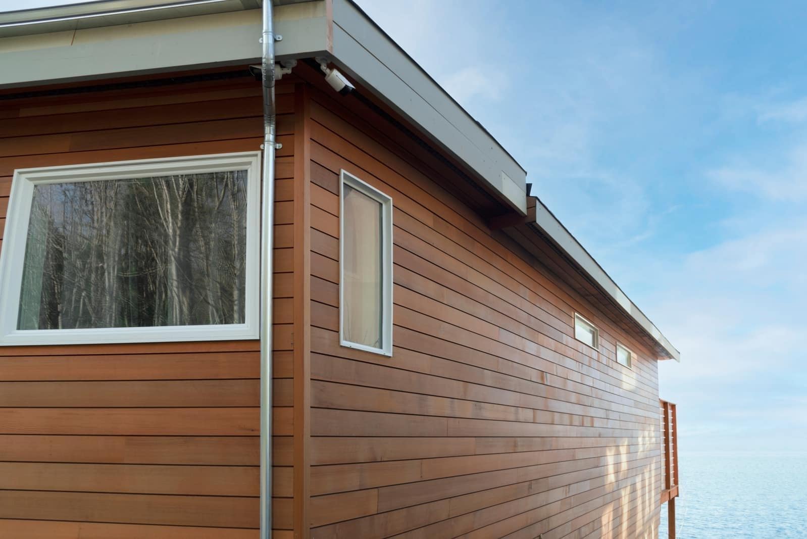 Roofline with a metal gutter run and downspout on a residential exterior